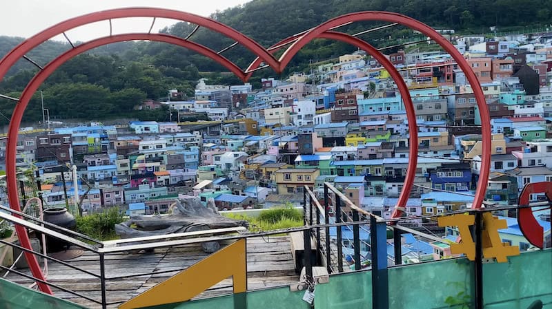A large empty Red Heart statue overlooking pastel houses at Gamcheon Culture Village