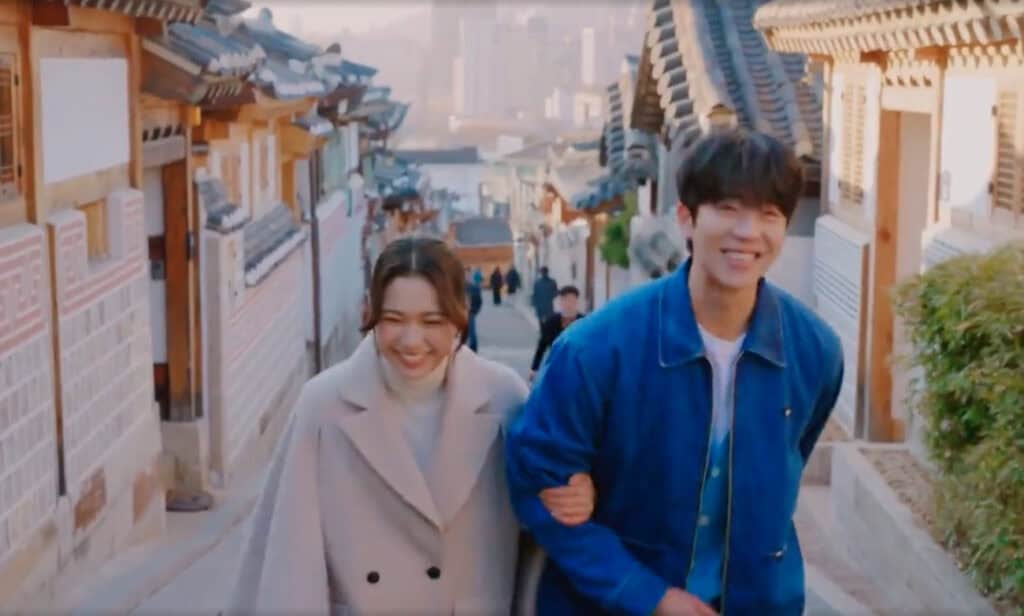 Laughing arm-in-arm, a couple strolls up Bukchon’s stone lane bathed in crisp winter light, savoring their budding romance in “Eye Love You," popular kdrama filming locations in Seoul